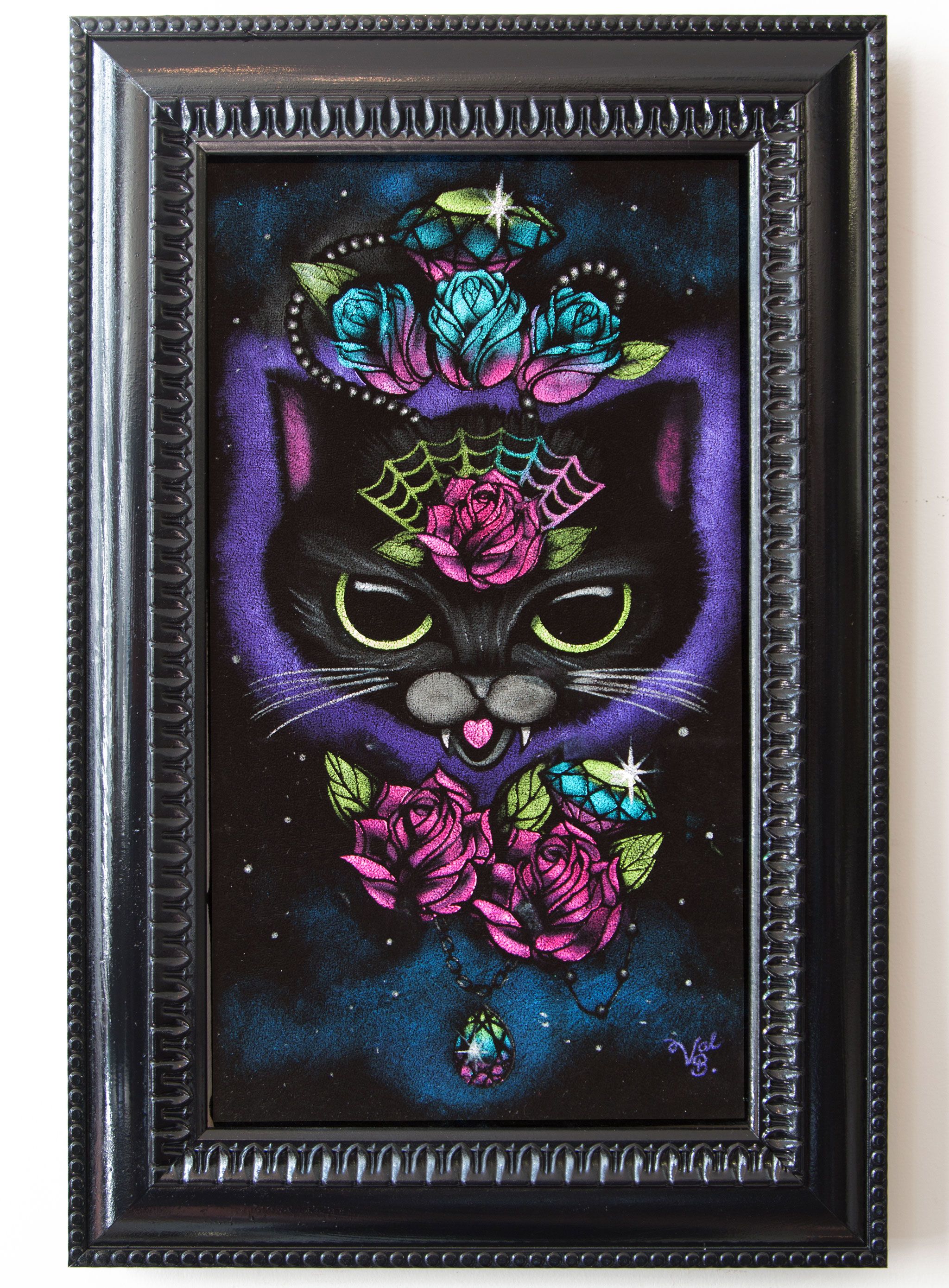 My Mystical Soulmate on Velvet. A black cat with green eyes, small fangs and a heart-shaped tongue, a spider web and pink rose on its brow and a crown of teal and pink roses, gems and pearls, on a purple and teal starry glow. Painted on black velvet in a black beaded frame.